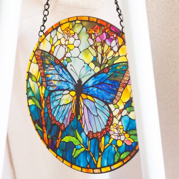 Foto detalle de un elemento decorativo de una mariposa con muchos colores en tonos verdes y azules que tiene Carmen en su local como decoración